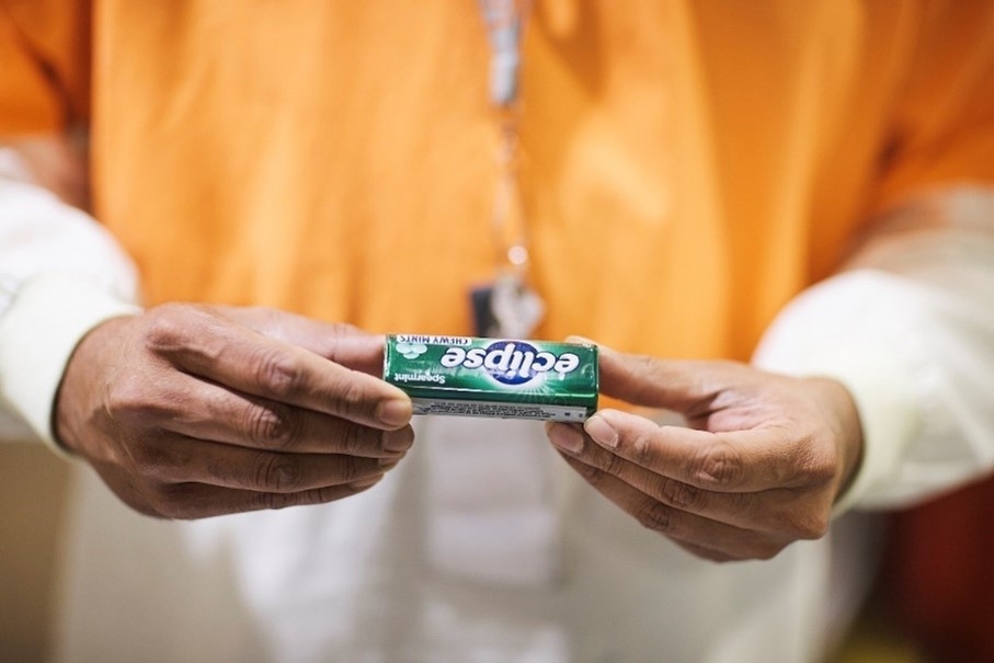 A man holding out a pack of Eclipse Spearmint Sugarfree Gum.