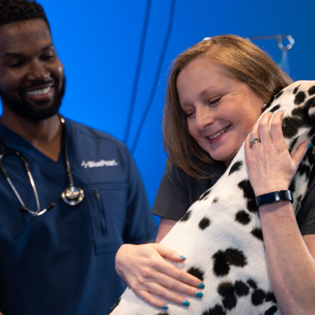 BluePearl vet with a pet owner hugging a Dalmatian