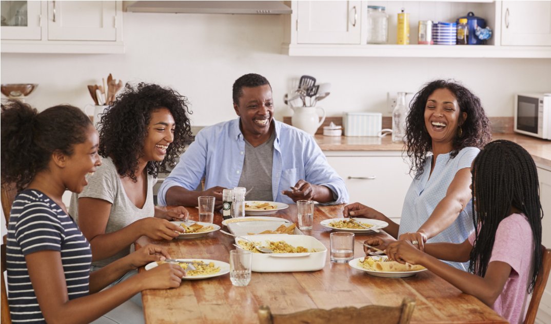 A family sitting together at the dinner table and smiling