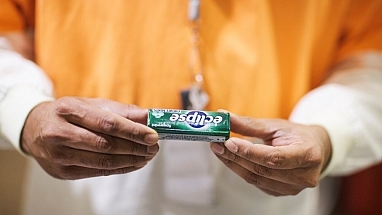 A man holding out a pack of Eclipse Spearmint Sugarfree Gum.