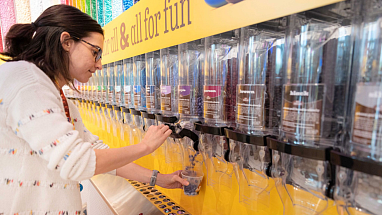 A woman refilling a bulk M&M's container