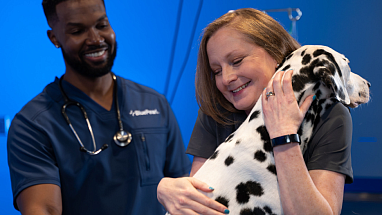 BluePearl vet with a pet owner hugging a Dalmatian