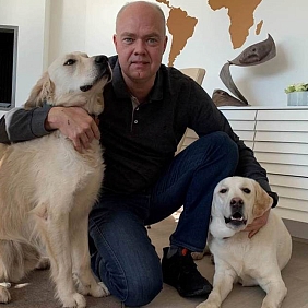 President of Mars Petcare Poul Weihrauch kneels beside his two dogs at his home. 