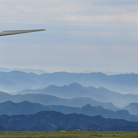 A windmill with rolling blue hills in the background