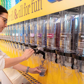 A woman refilling a bulk M&M's container
