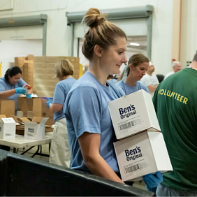 A volunteer carries boxes of Ben's Original rice