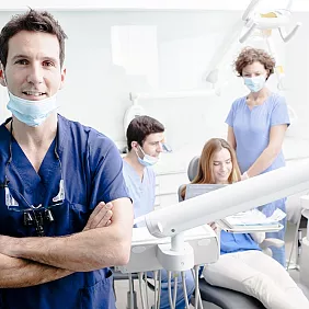 Dentist and staff near patient
